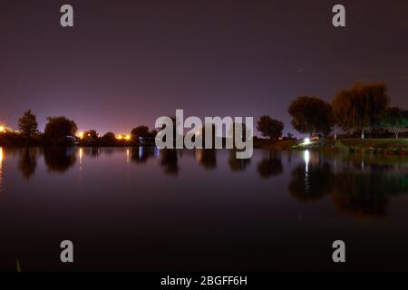 Nachtaufnahmen mit See und Bäumen Stockfoto