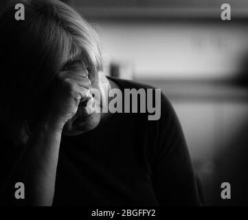 Ältere depressive Frau mit Kopf auf ihr ruhend hand.in ein häuslichen Umgebung. Stockfoto