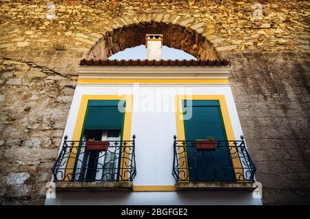 Häuser in Evora (Alentejo, Portugal) entlang des alten Aquädukts Agua da Prata. Gebäude wurden direkt zwischen den Bögen des Aquädukts gebaut Stockfoto