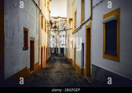 Sonnenuntergang in den engen Gassen von Evora, der Hauptstadt der Alentejo Region in Portugal, berühmt für seine traditionellen weißen und gelben Häuser Stockfoto