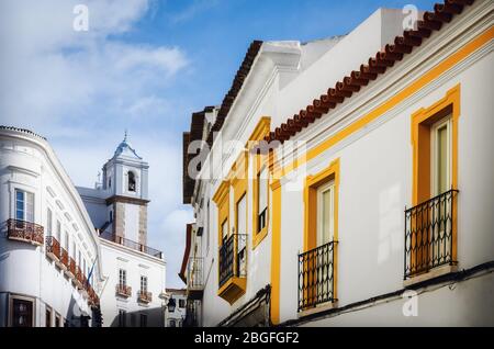 Die engen Gassen von Evora, der Hauptstadt der Region Alentejo in Portugal, berühmt für ihre traditionellen weißen und gelben Häuser Stockfoto