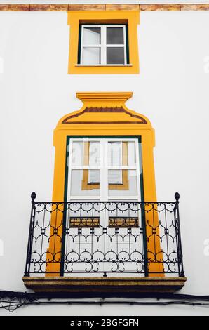 Ein traditionelles Fenster mit Balkon in Evora, der Hauptstadt der Alentejo Region in Portugal, berühmt für seine weißen und gelben Häuser Stockfoto