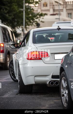 Weiße Limousine auf der Hauptstraße, in der Ampel warten, Blick von hinten Stockfoto