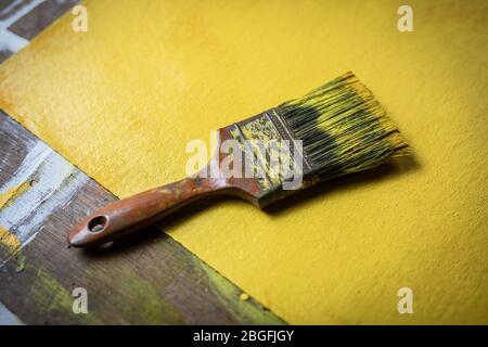Ein Pinsel mit gelber Farbe im Künstlerstudio. Stockfoto
