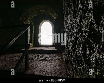 Bogenfenster in alten befestigten Hell Fire Club Jagd Protokolle in Dublin, Irland, Blick von innen mit hellem Licht scheint auf dicken Granitwänden Stockfoto