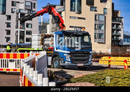 Blauer Volvo FM mit LKW-Kran von Kuljetus Oy Laakso auf der Baustelle in Helsinki, Finnland. 25. März 2020. Stockfoto