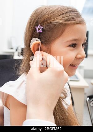 Kleines Mädchen während der Hörprüfung im Büro des Audiologen. Hörklinik Stockfoto