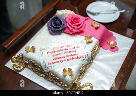 Ein weißer Kuchen für Hari gemacht. Rosa und lila Kuchen. Durch Gottes Befehl, mit der Erlaubnis des Propheten, sind wir gekommen, um für Ihre Tochter zu bitten Stockfoto