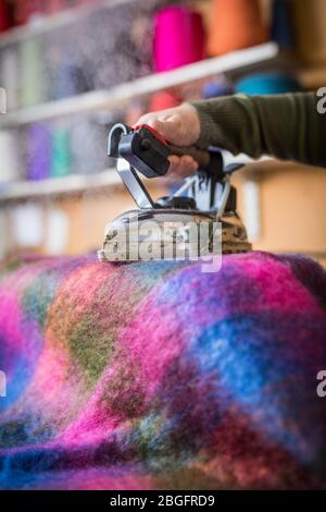 Ein Kleidungsstück, das in einer Textilfabrik gedämpft wird. Stockfoto