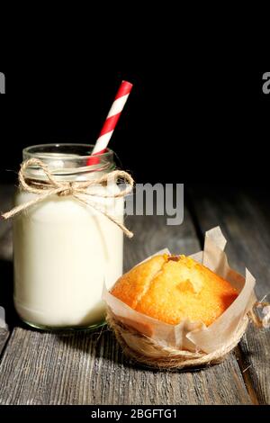 Milch in Flaschen mit Papphalmen auf dem Tisch Stockfoto