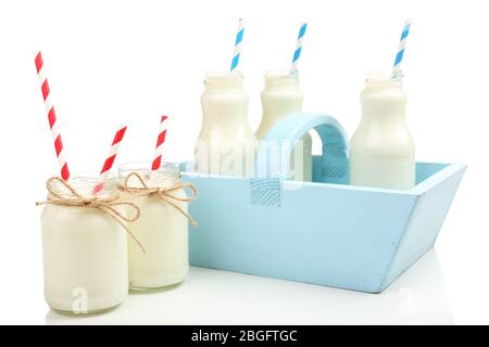 Milch in Flaschen mit Papierhalmen auf weiß isoliert Stockfoto