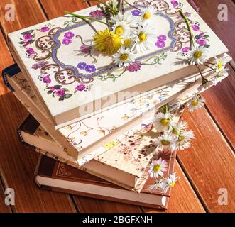Bücher und Blumen auf dem Tisch im Garten Stockfoto
