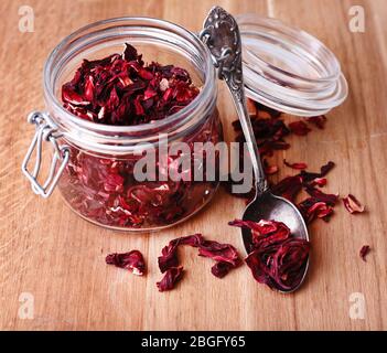 Getrockneter Hibiskus-Tee im Glas auf Holzhintergrund Stockfoto
