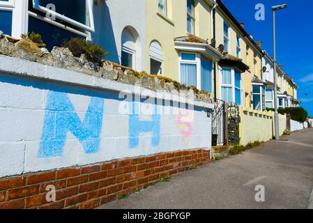 Wyke Regis, Weymouth, Dorset, Großbritannien. April 2020. Ein Kreidewandbild an einer Wand vor einem Haus, das den NHS mit einem Superman-Symbol bei Wyke Regis in Dorset während der anhaltenden Sperrung der Coronavirus-Pandemie unterstützt. Bild: Graham Hunt/Alamy Live News Stockfoto