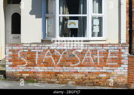 Wyke Regis, Weymouth, Dorset, Großbritannien. April 2020. Ein Kreidegemälde an einer Wand vor einem Haus mit der Aussage Stay Safe zur Unterstützung des NHS bei Wyke Regis in Dorset während der anhaltenden Sperrung der Coronavirus-Pandemie. Bild: Graham Hunt/Alamy Live News Stockfoto