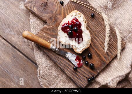 Frischen Toast mit selbst gemachter Butter und schwarze Johannisbeere Marmelade auf hölzernen Hintergrund Stockfoto