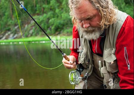 Fliegenfischen Angler macht werfen, während im Wasser stehen Stockfoto