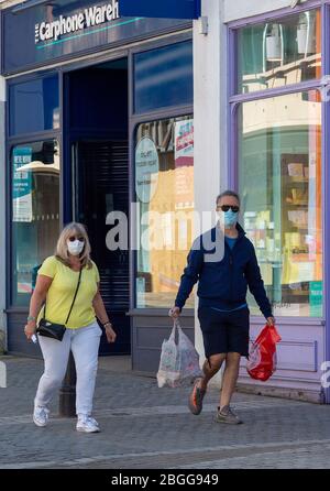 Windsor, Berkshire, Großbritannien. April 2020. Ein Paar trägt Masken, während sie ihre wichtigsten Einkäufe in Peascod Street, Windsor während der Coronavirus Lockdown. Kredit: Maureen McLean/Alamy Stockfoto