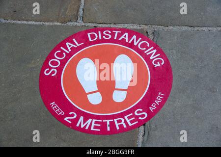 Windsor, Berkshire, Großbritannien. April 2020. Ein Social Distancing Aufkleber für die Schlange von Kunden vor einem Geschäft auf der Straße in Peasod Street, Windsor. Kredit: Maureen McLean/Alamy Stockfoto