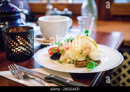 Köstliche traditionelle dänische Sandwiches smorrebrod mit dunklen Roggenbrot, Garnelen, gekochte Eier, schwarzen Kaviar, Zitrone und grünen Sprossen Stockfoto