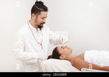 Traditionelle chinesische Medizin Arzt tun Akupunktur auf der Stirn der Frau, um Stress und Migräne zu lindern. Stockfoto