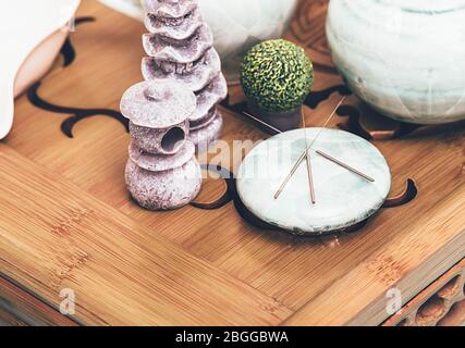 Akupunkturnadeln aus nächster Nähe. Zusammensetzung von Nadeln und Steinen auf einem Tisch in einem Spa-Salon zur Entspannung Stockfoto