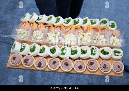 Kellner hält Holzplatte mit vegetarischen Vorspeisen Stockfoto