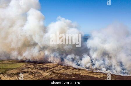 Ballycastle Nordirland-21. April 2020. 70 Feuerwehrleute aus ganz Nordirland besuchen die außer Kontrolle geratenen Waldbrände Feuerwehrleute kämpfen in der Nähe von Ballycastle in der Grafschaft Antrim gegen zwei große Waldbrände. Auch Spezialeinheiten wurden aufgrund der Beschaffenheit des Geländes beauftragt. Trockene Böden behindern ihre Bemühungen und Rauch aus dem Feuer kann von Antrim Stadt und Coleraine gesehen werden.Bildquelle: Steven McAuley/Alamy Live News Stockfoto