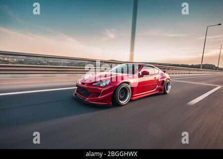 Roter Rennwagen auf der großen großen Autobahn mit Panoramablick, Winkel-Ansicht Stockfoto