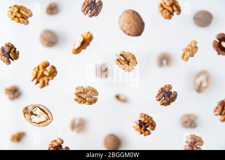 Geschälte Walnüsse fliegen über weißem Hintergrund, Levitation-Effekt. Stockfoto