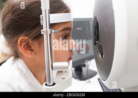 Tomographie der Augen eines kleinen Mädchens Patienten. Moderne Augentestgeräte. Mädchen Gesicht aus nächster Nähe. Sehkorrektur Stockfoto
