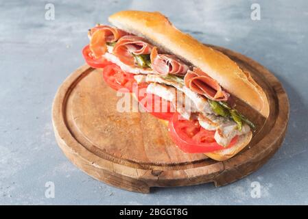 Sandwich Serranito typisch in Andalusien mit Schinken, gren Pfeffer und gegrilltem Schweinefleisch Lende Stockfoto