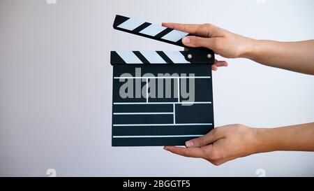 In der Hand hölzerne schwarze Klapptafel isoliert auf grauem Hintergrund. Stockfoto