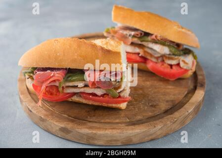 Sandwich Serranito typisch in Andalusien mit Schinken, gren Pfeffer und gegrilltem Schweinefleisch Lende Stockfoto