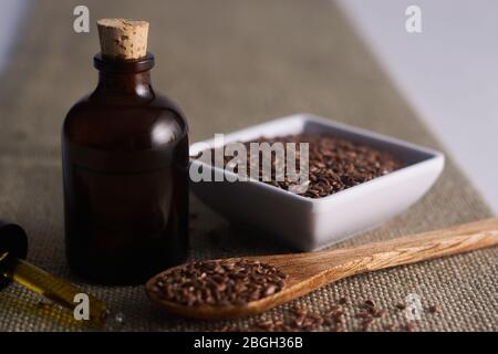 Leinöl mit weißem Hintergrund und Leinsamen in einer weißen Tasse Stockfoto