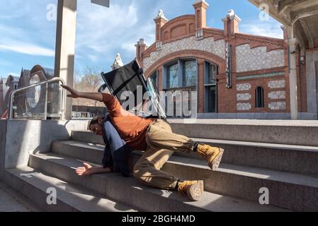 Behinderter Latino-junger Mann im Rollstuhl fällt eine Treppe hinunter, die er nicht mit dem Stuhl auf der Straße hinuntergehen kann Stockfoto