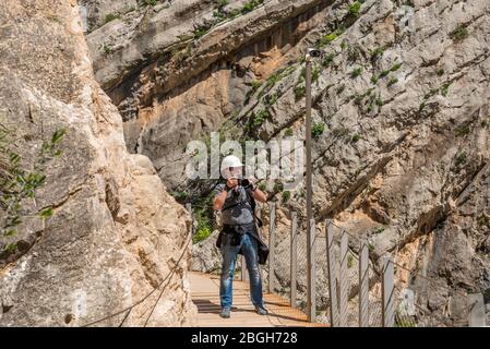 17. April 2018 - El Chorro, Spanien. Tourist, der neben einer der vielen Überwachungskameras entlang des Caminito del rey fotografiert. Stockfoto