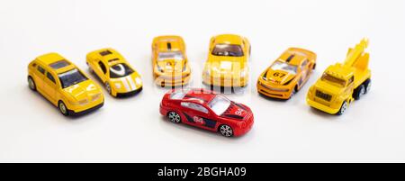 Ein rotes Autospielzeug umgeben von orangen Autos Stockfoto