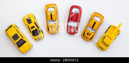 Ein rotes Autospielzeug umgeben von orangen Autos Stockfoto