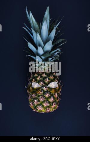 Eine reife Ananas mit gelben Gläsern auf schwarzem Hintergrund Stockfoto