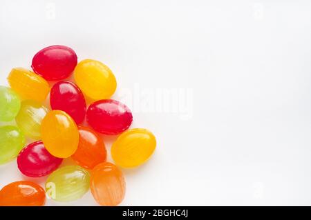 Mehrfarbige Karamell-Bonbons auf weißem Hintergrund. Platz für Text. Gelbe, rote, grüne Süßigkeiten. Stockfoto