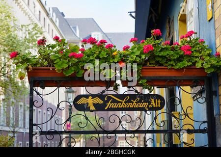 Bierkneipe in einer romantischen Gasse in der Altstadt. Typische regionale Dekoration, Blumen und Bierwerbung. "Frankenheim Alt" ist eine lokale Biermarke. Stockfoto