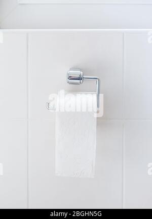 Letzte Toilettenpapierrolle, die am Halter hing. Symbol für Kaufpanik während Corona-Virus Stockfoto