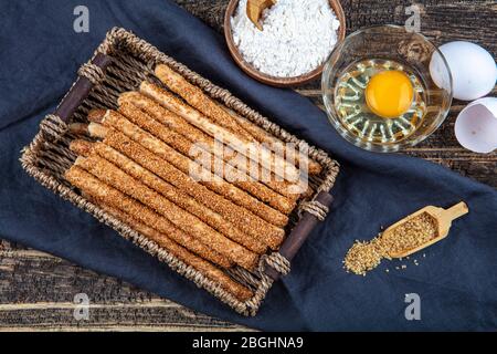 Frisch gebackene hausgemachte Grissini-Brotsticks mit Sesam auf Holzhintergrund. Selektiver Fokus Stockfoto