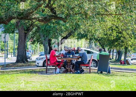 Senioren spielen Dominos auf der Median der Galvez Street in Mid City, New Orleans, Louisiana, USA Stockfoto
