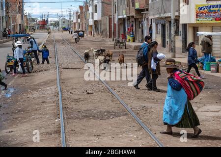 Die Einheimischen von Puno, Peru, machen ihre täglichen Geschäfte und überqueren die Bahngleise Stockfoto