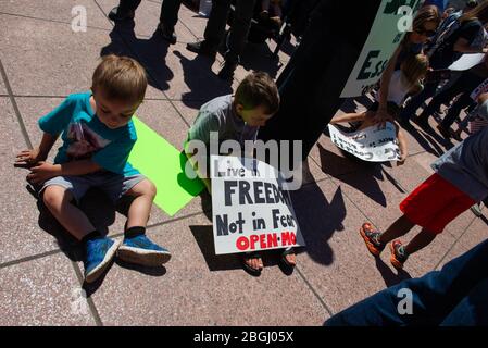 St. Louis, Missouri, USA. April 2020. Kinder nehmen Platz bei einem Protest gegen COVID-19 Aufenthalt zu Hause Befehle an der Missouri State Capitol in Jefferson City. Kredit: James Cooper/ZUMA Wire/Alamy Live News Stockfoto