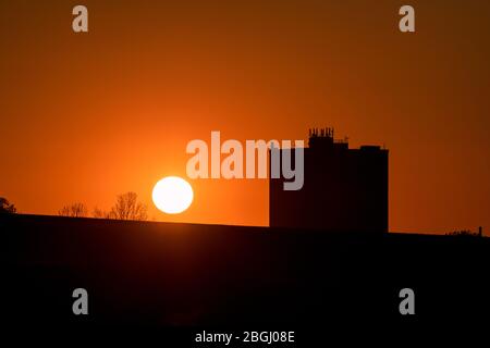 Als die Sperrung aufgrund der Coronavirus-Pandemie in die fünfte Woche einzieht, geht die Sonne angesichts des Wohnblocks Humphries Houes in Brownhills, Walsall, in den West Midlands, Großbritannien, unter. Stockfoto