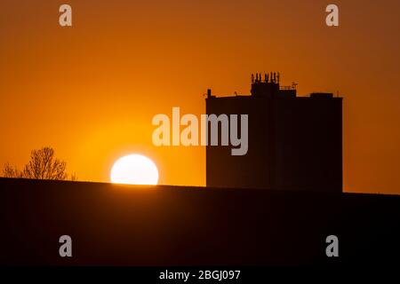 Als die Sperrung aufgrund der Coronavirus-Pandemie in die fünfte Woche einzieht, geht die Sonne angesichts des Wohnblocks Humphries Houes in Brownhills, Walsall, in den West Midlands, Großbritannien, unter. Stockfoto