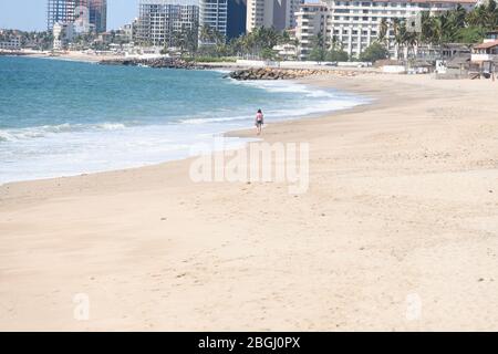 Aufenthalt zu Hause ist und Bild einer einzelnen Person, die entlang eines einsamen Strandes während Coronavirus Lock Down. Stockfoto